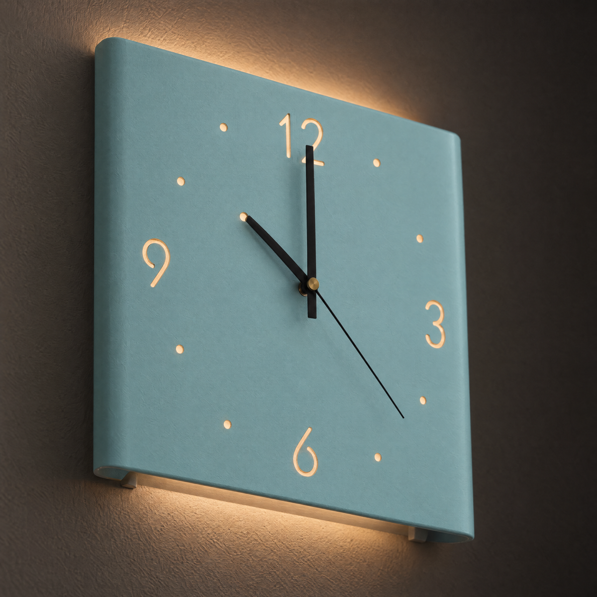 Linea wall clock in Light Blue showing cut-out numerals and warm backlighting