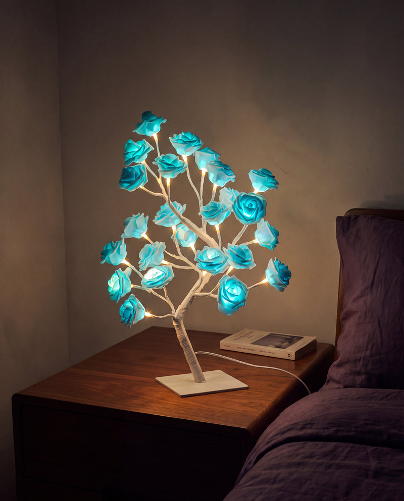 Blue Floreo rose tree lamp lit on a bedside table