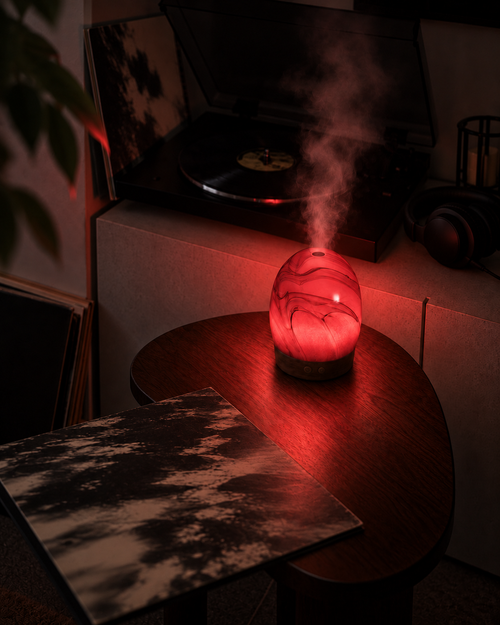 Astrum glowing romantic red beside a record player and albums, with mist rising from its visible top opening