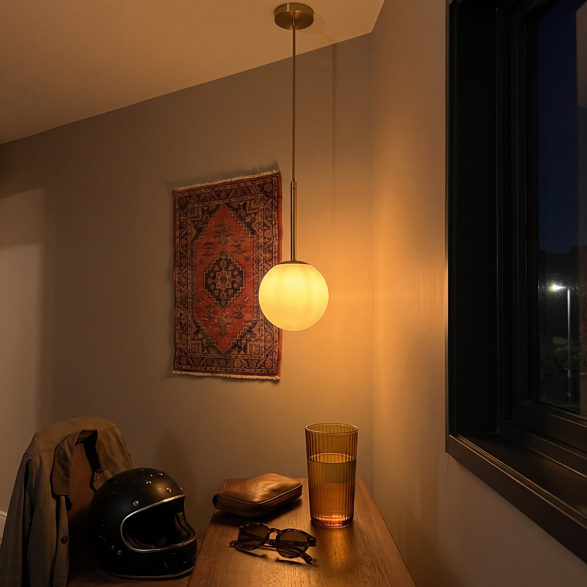 The pendant above a hallway console at night