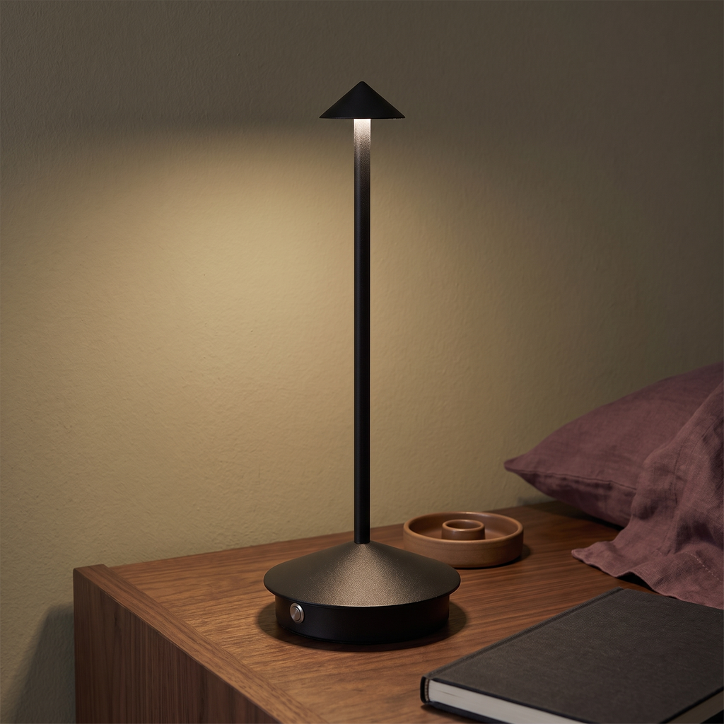 Black Spire cone table lamp on a warm bedside table