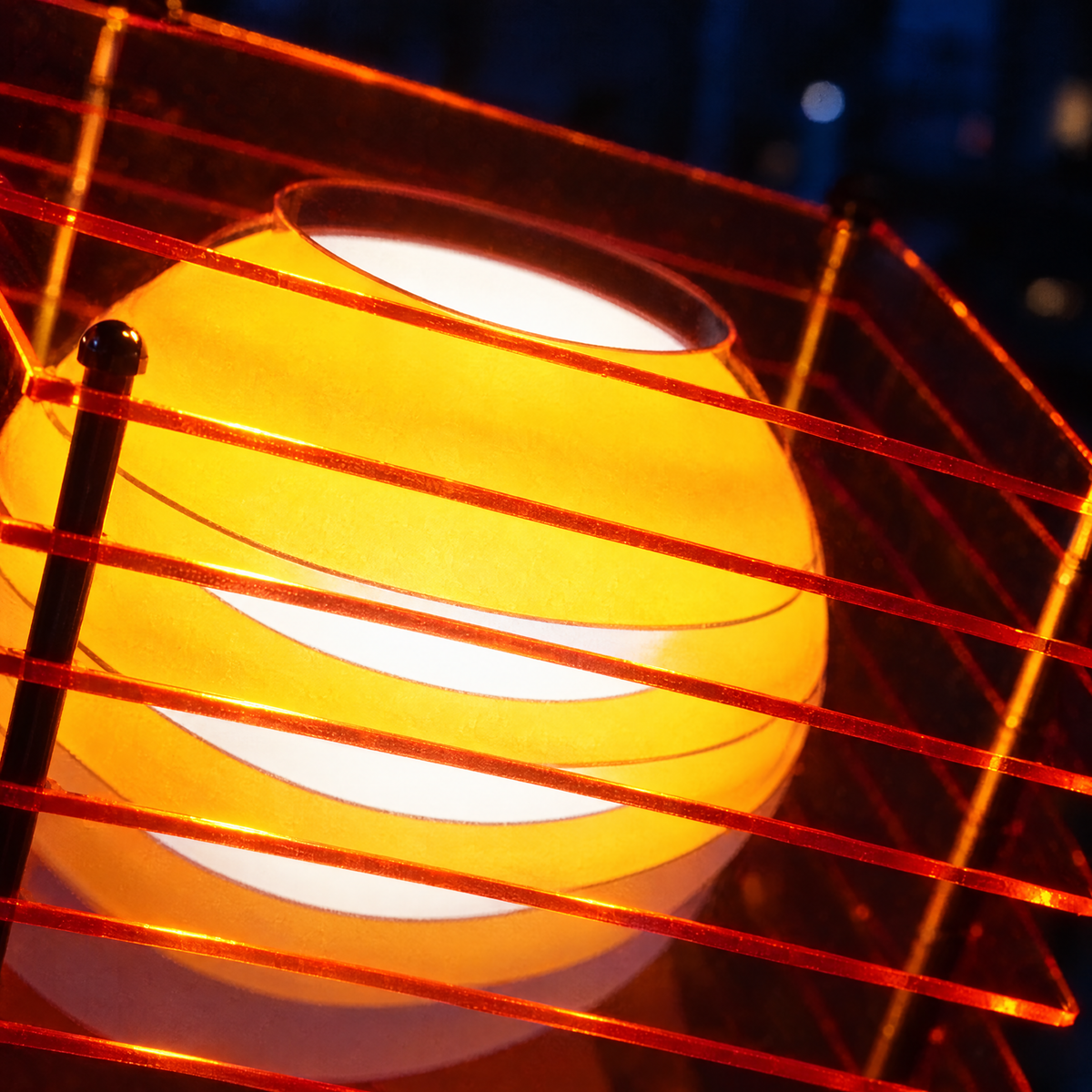 Close-up of Strata Orange showing the glowing sphere and layered acrylic edges