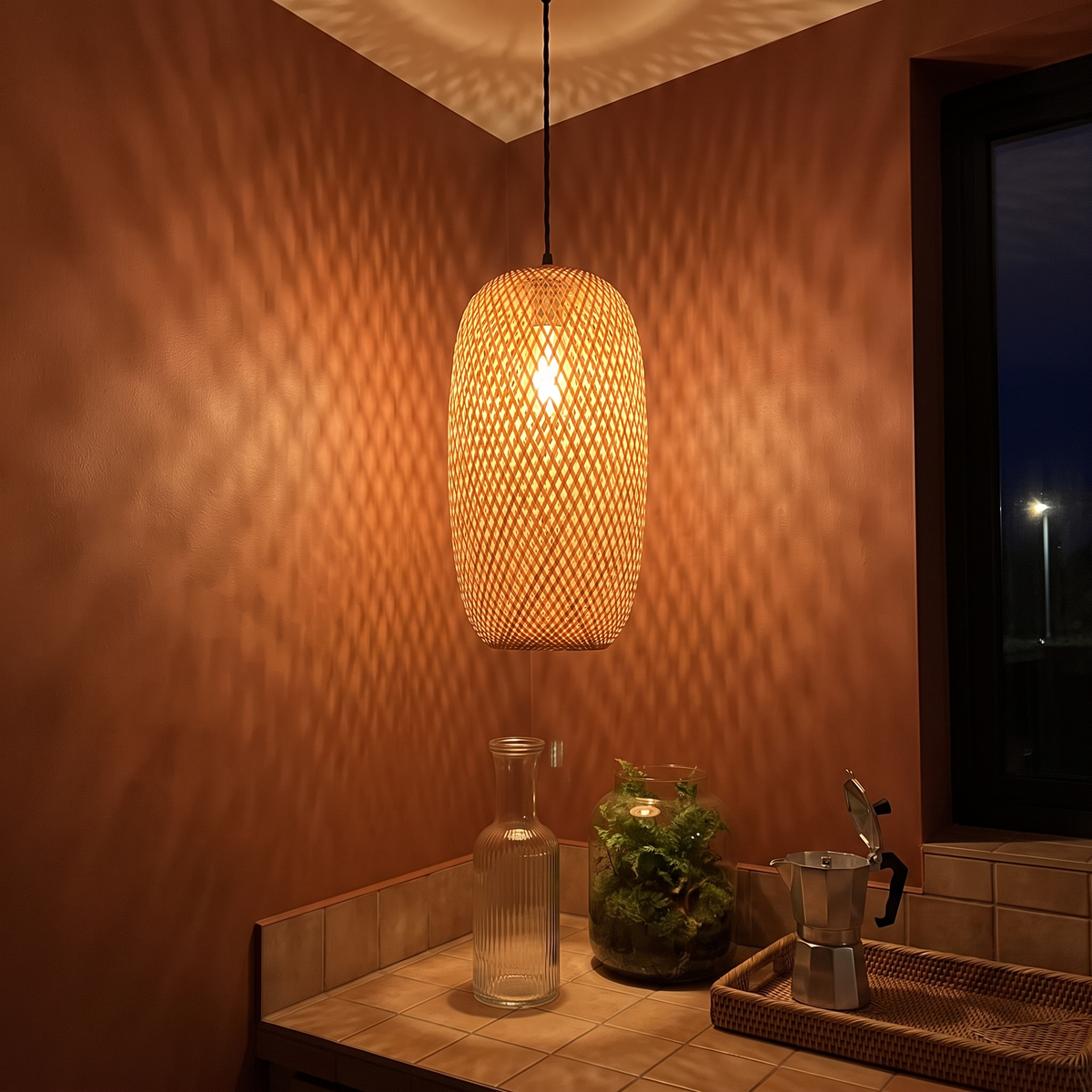 Tessera woven bamboo pendant over a tiled kitchen counter at night