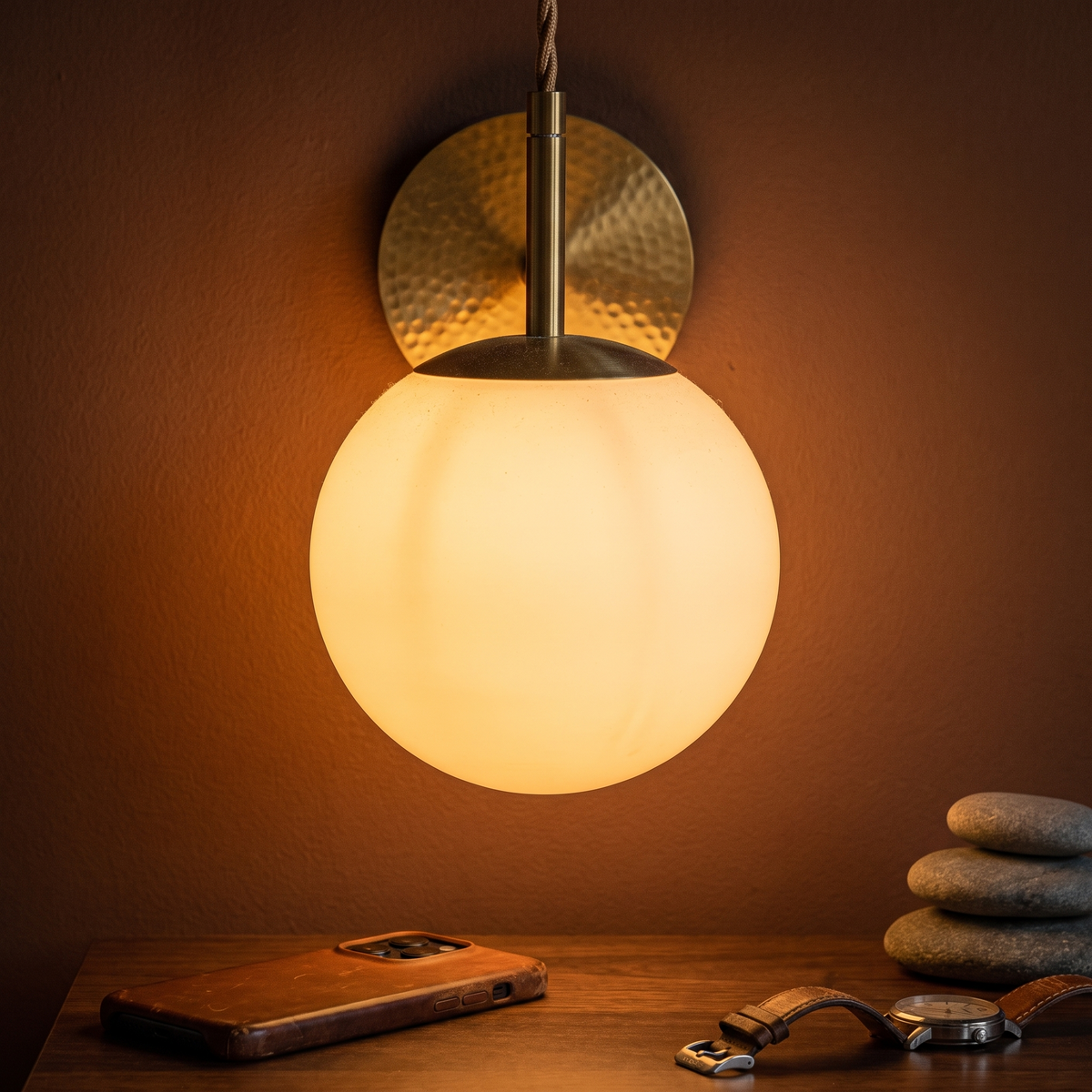 Opal glass globe pendant, copper finish with milk white glass, lit against a clay wall